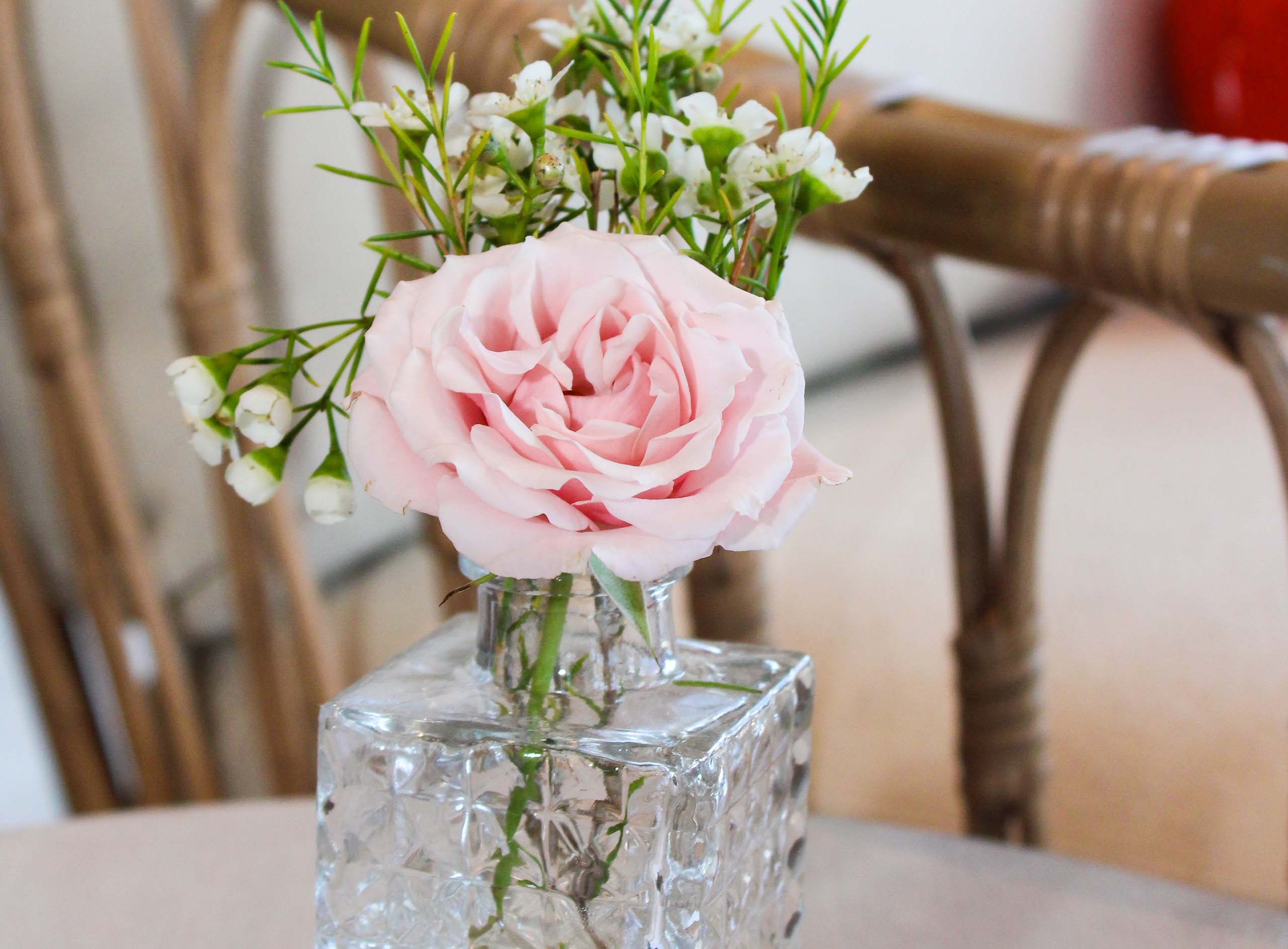 baby shower with pink rose in a vase at a table setting